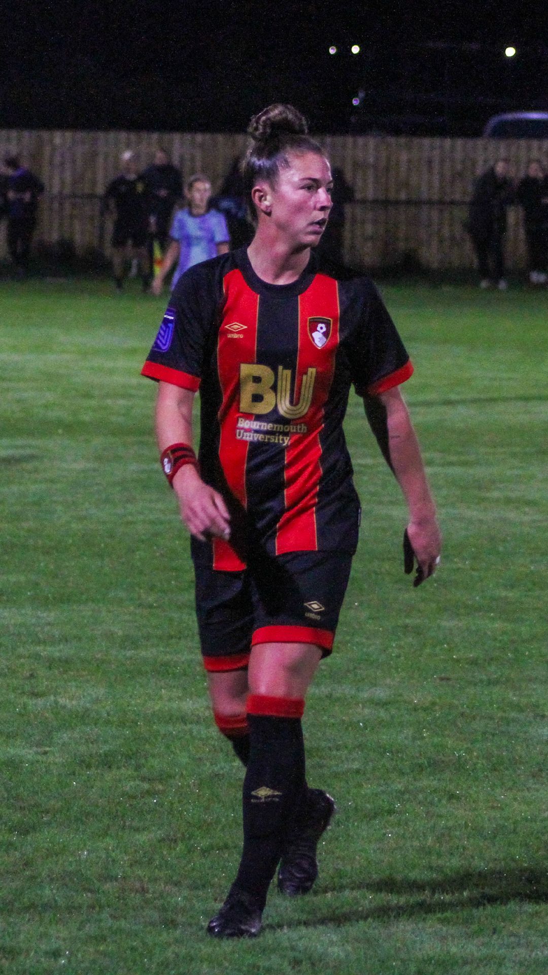Molly Barron-Clark in the Bournemouth home kit looking to her left with a Bournemouth sweatband on her right arm