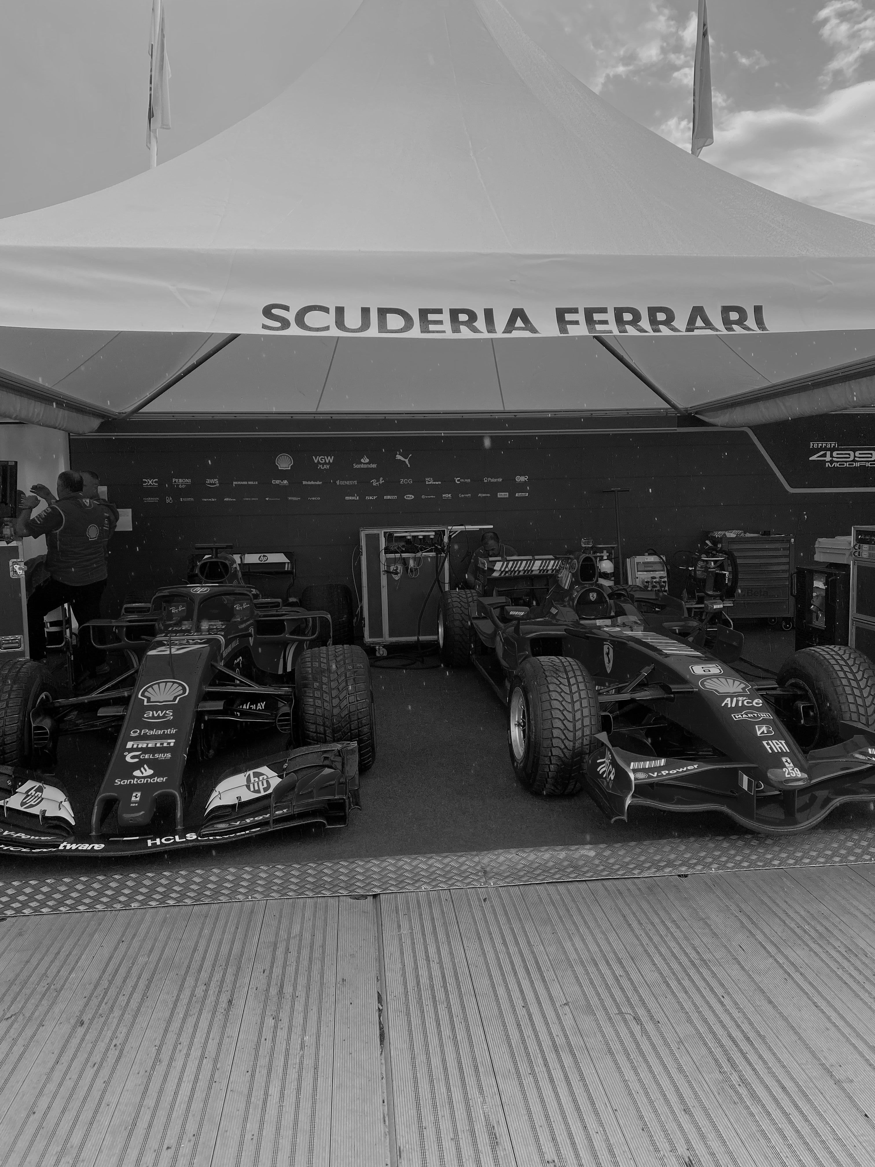 Ferrari cars sitting in the Scuderia Ferrari garage at Goodwood Festival of Speed, picture is black and white