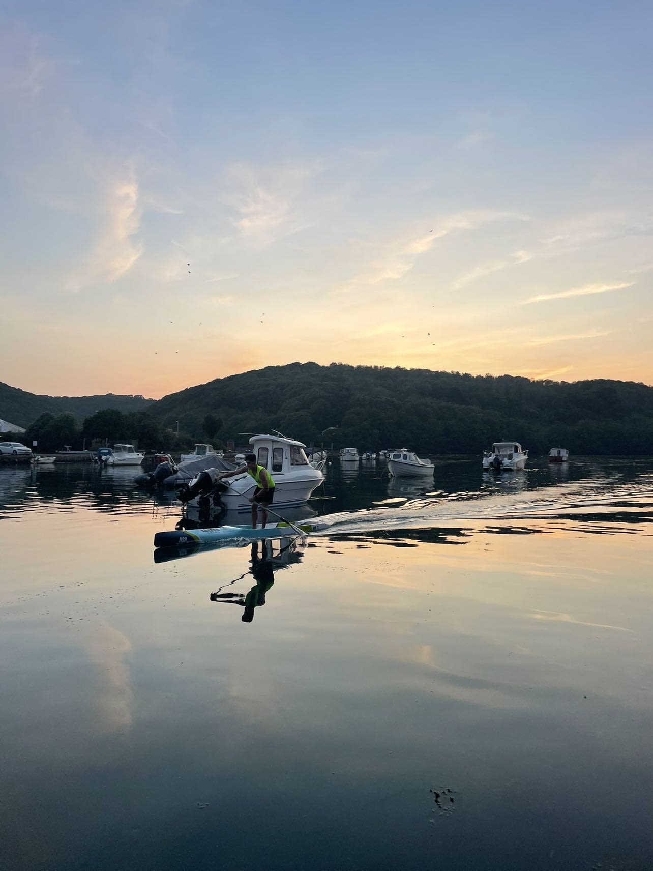 silhouette of person on boat holding paddle during golden hour