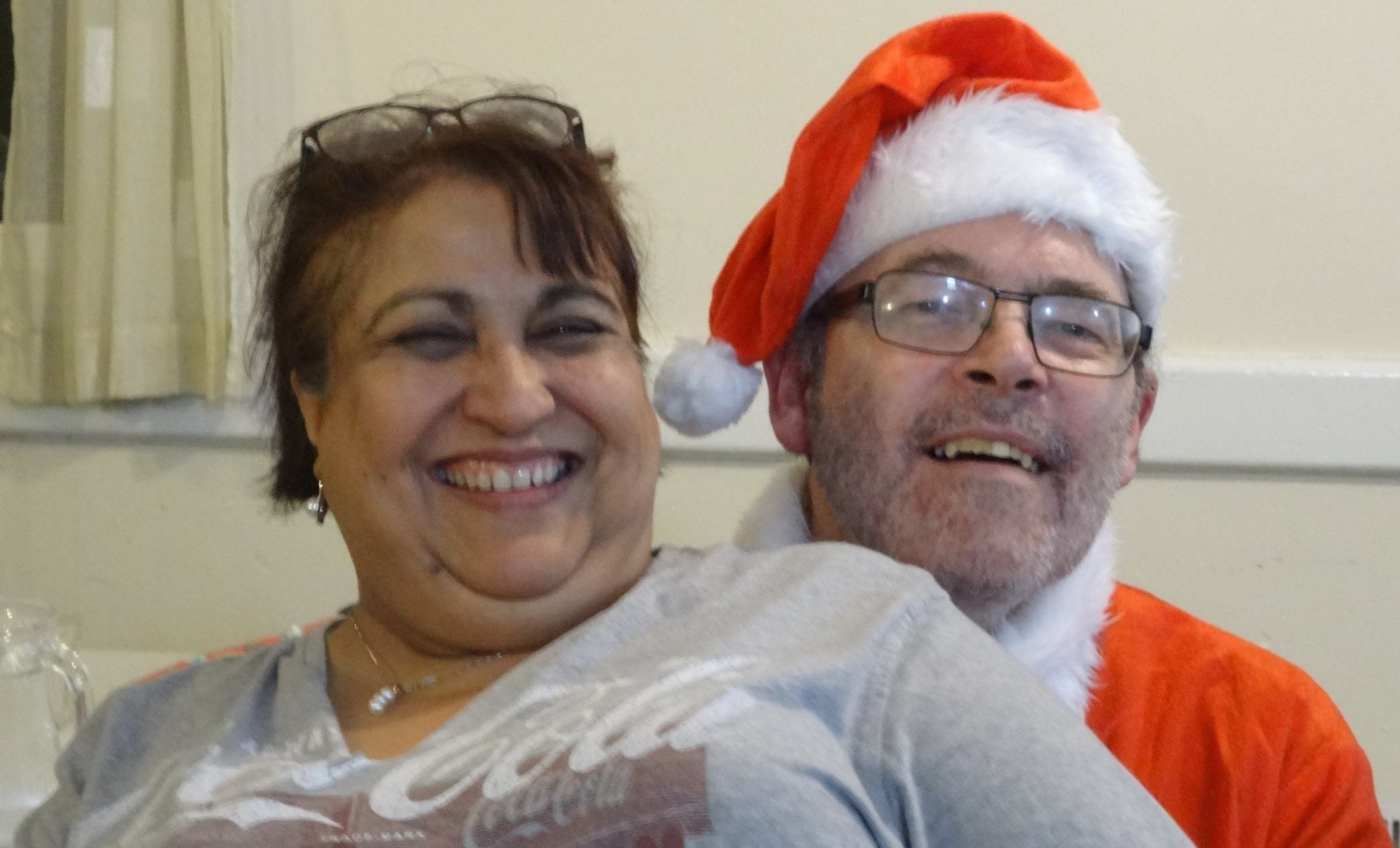 Mark in a Santa suit, smiling with Kamlesh