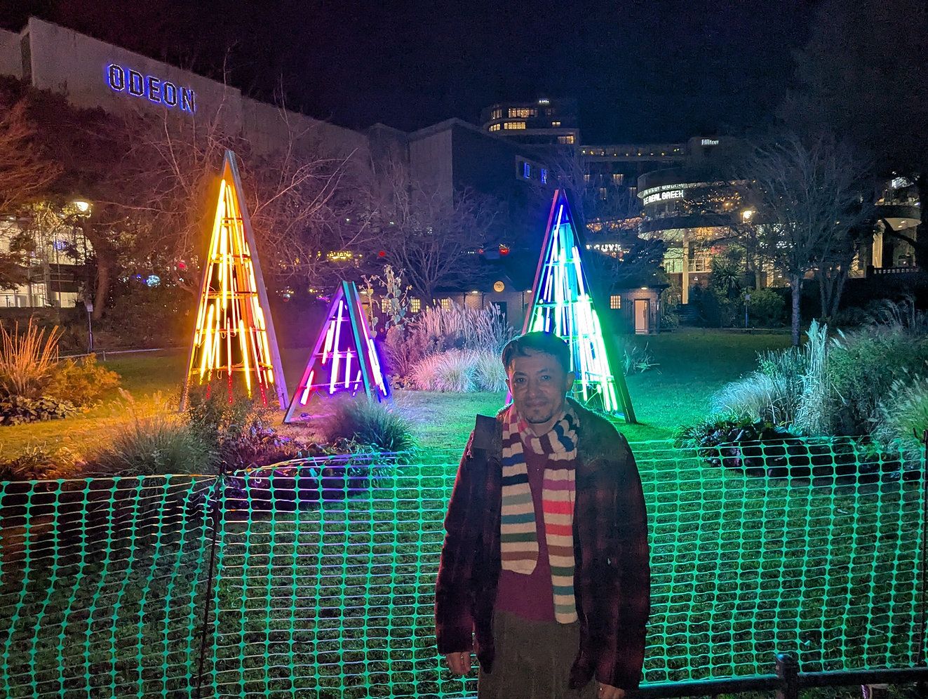 Joel, a trans man standing in front of the Bournemouth Christmas decorations